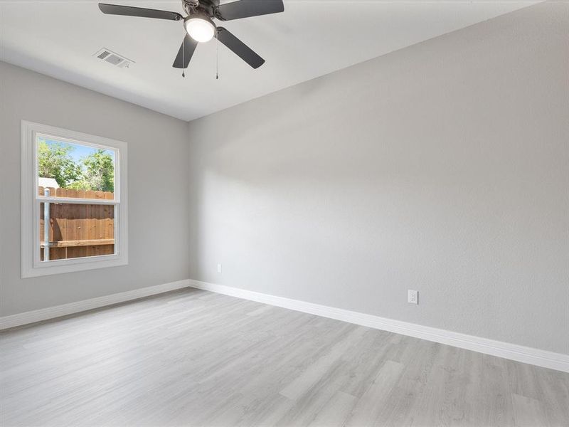 Unfurnished room with light wood-type flooring, baseboards, and a ceiling fan