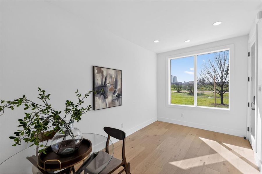 Office space/bedroom with light wood-type flooring and recessed lighting
