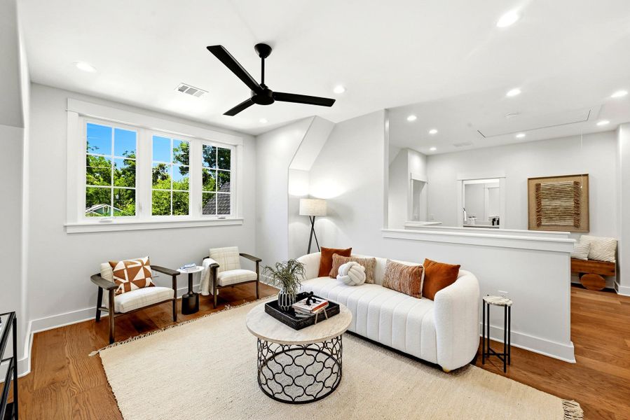Sun-filled living area features rich wood flooring, high ceilings, and a clear view of mature trees. Sun-filled living area features rich wood flooring, high ceilings, and a clear view of mature trees.