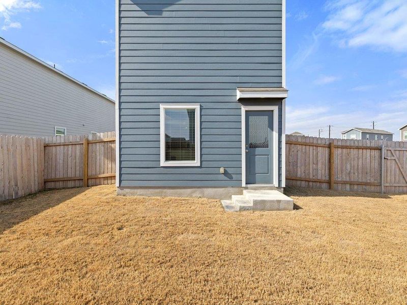 Back of house with a fenced backyard
