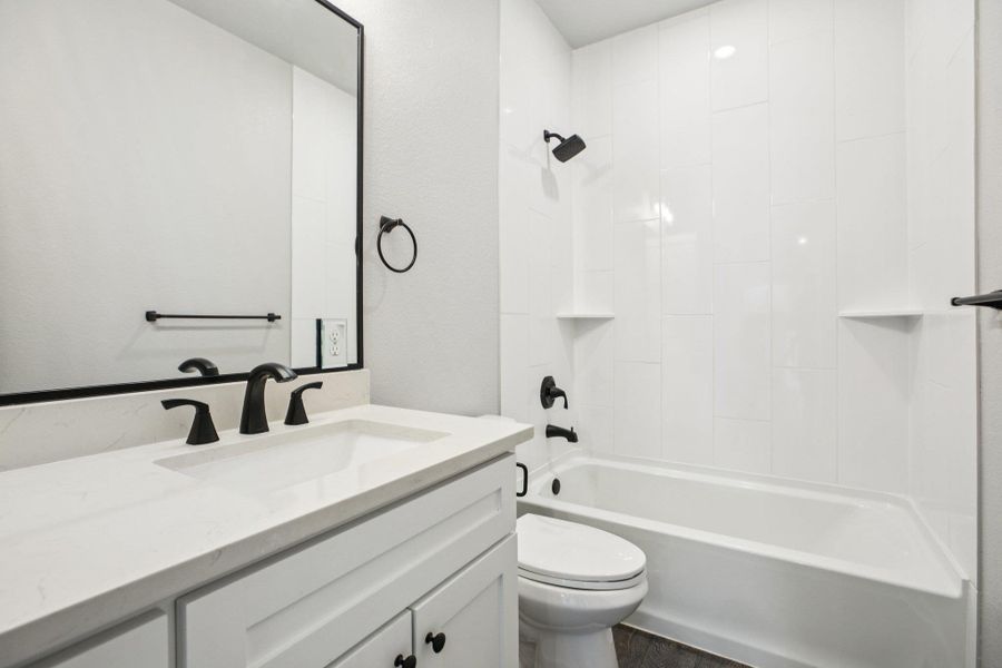 Full bath featuring bathtub / shower combination, vanity, and dark wood-style flooring