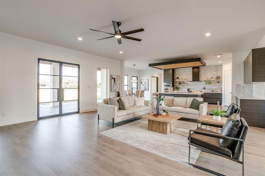 Living area featuring light wood finished floors, recessed lighting, and ceiling fan Living area featuring light wood finished floors, recessed lighting, and ceiling fan