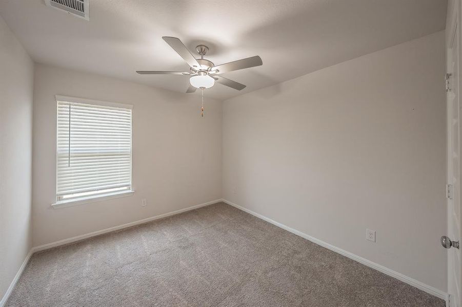 Spare room featuring light colored carpet and a ceiling fan Spare room featuring light colored carpet and a ceiling fan