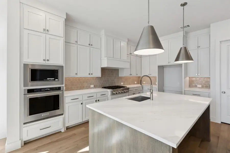 This dream kitchen features double stacked cabinets, designer backsplash, gorgeous countertops and high end stainless appliances.  What more could you ask for?