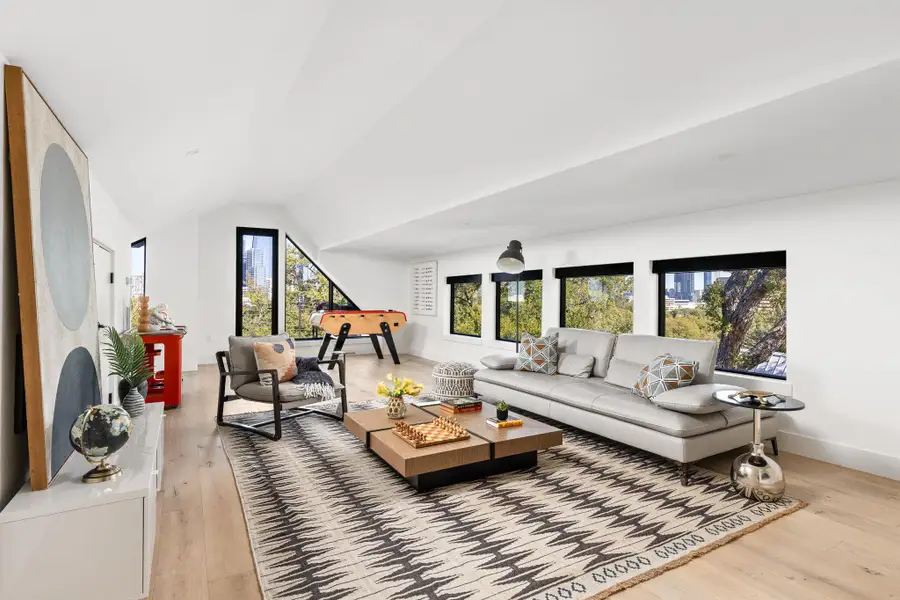 Living room with light wood-style flooring and vaulted ceiling Living room with light wood-style flooring and vaulted ceiling