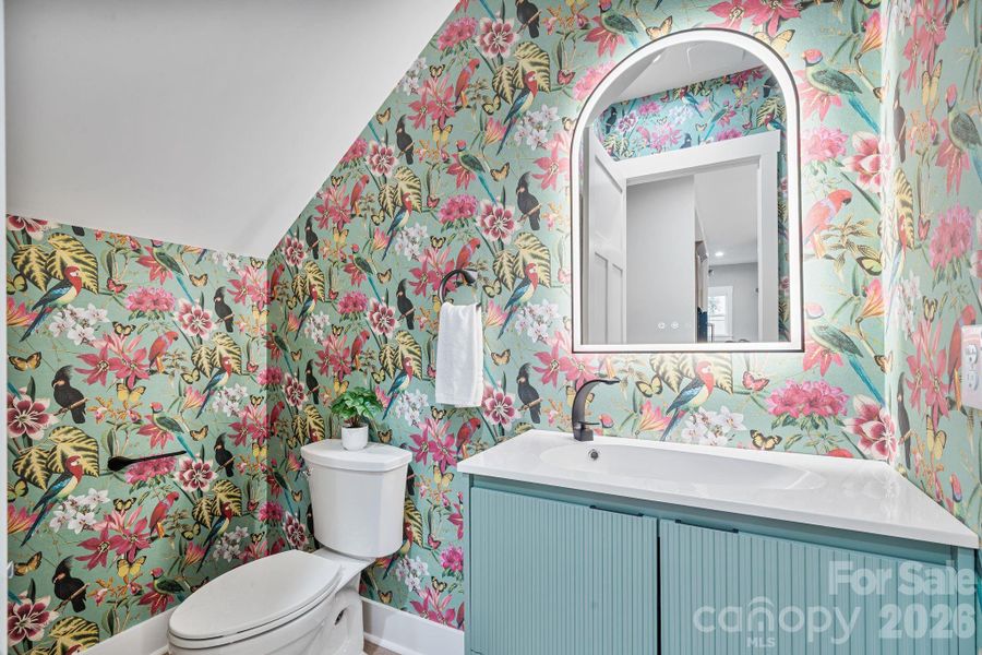 Half bath with floating vanity and statement wallpaper