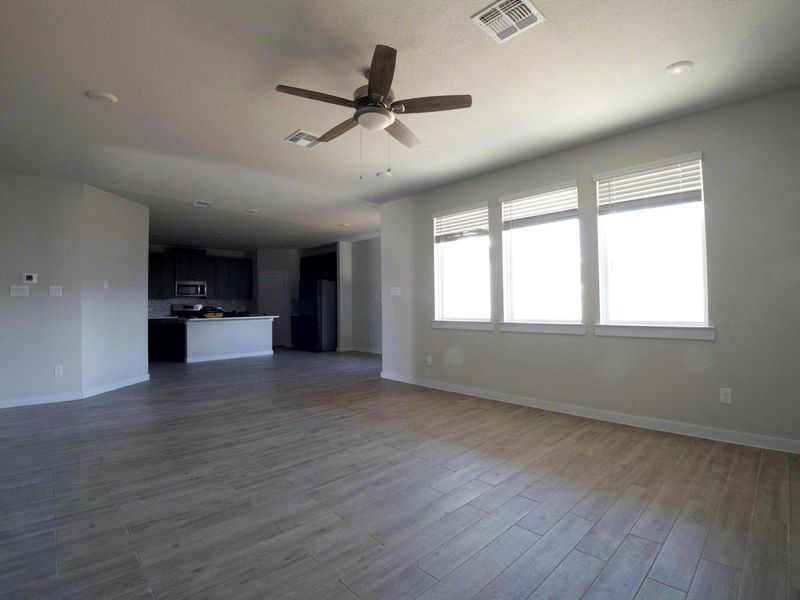 Unfurnished living room with ceiling fan and dark wood finished floors Unfurnished living room with ceiling fan and dark wood finished floors