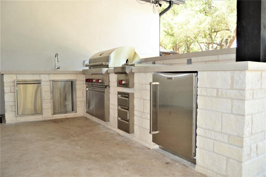 View of patio featuring exterior kitchen View of patio featuring exterior kitchen