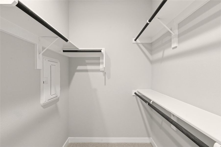 Spacious closet with electric panel and carpet floors