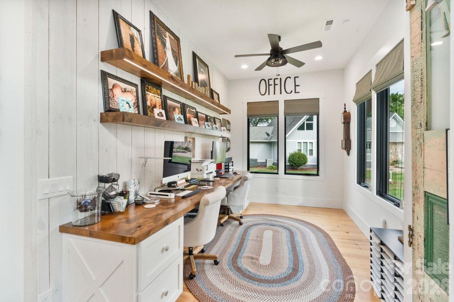 Main level office with open shelving adds warmth and farmhouse character Main level office with open shelving adds warmth and farmhouse character