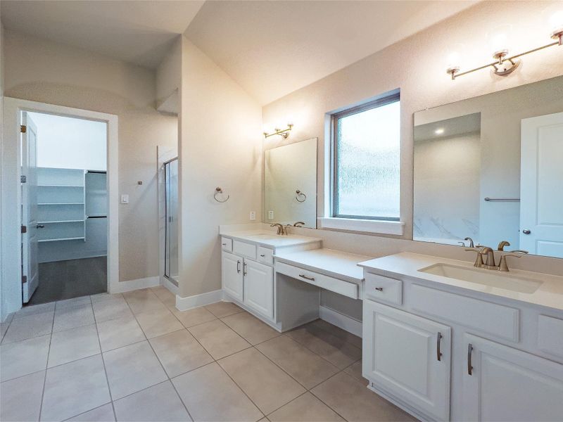 Full bathroom with double vanity, light tile patterned flooring, a stall shower, and a walk in closet Full bathroom with double vanity, light tile patterned flooring, a stall shower, and a walk in closet