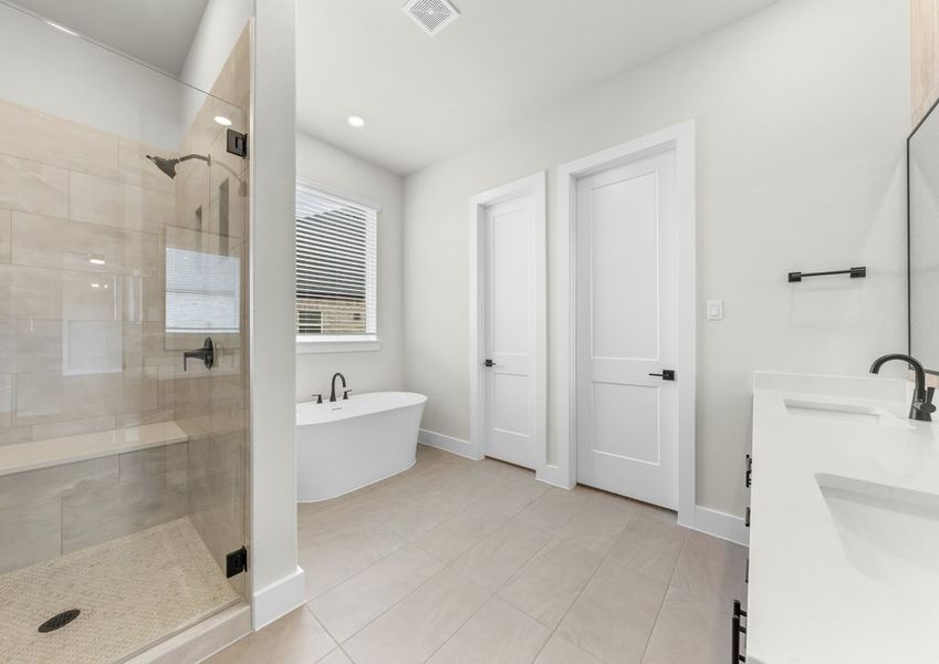The master bathroom has a glass, walk-in shower and garden tub.
