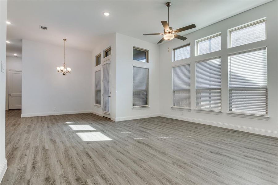 Living room & dining area featuring ceiling fan in living room, Chandelier over dining area, high ceilings with modern canned lighting