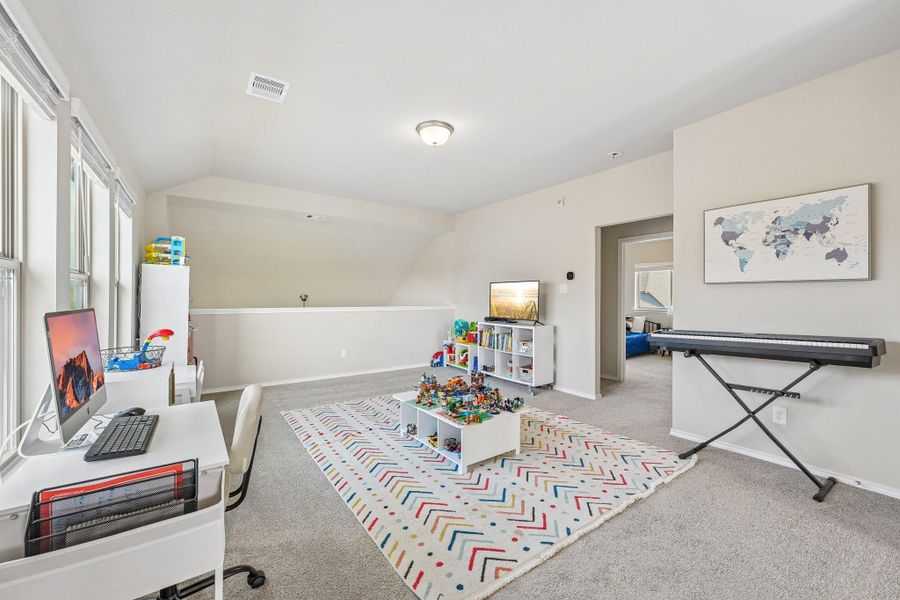 Bright and versatile bonus room with large windows, perfect for a home office or play area, featuring ample space for creativity and relaxation.