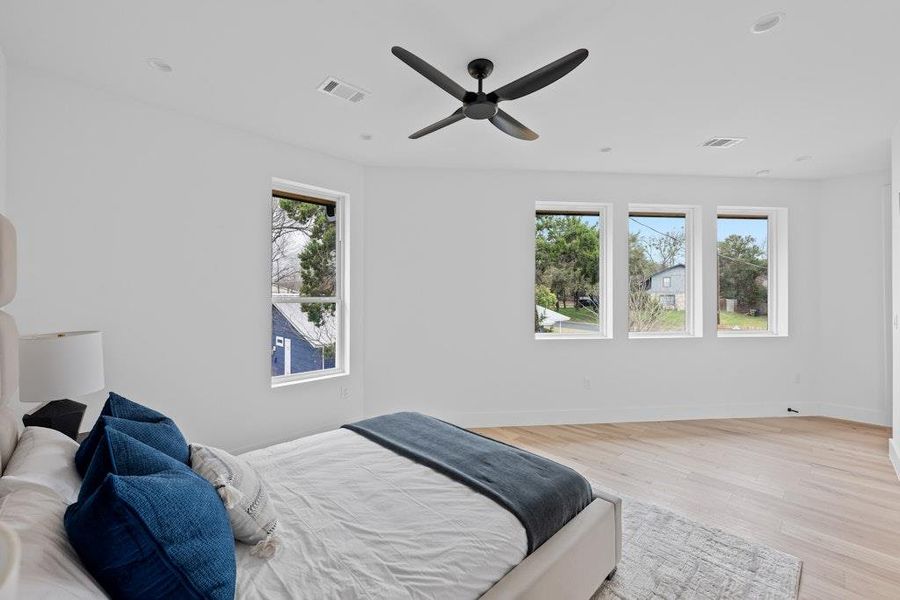 Bedroom featuring light wood-style floors, multiple windows, a ceiling fan, and recessed lighting