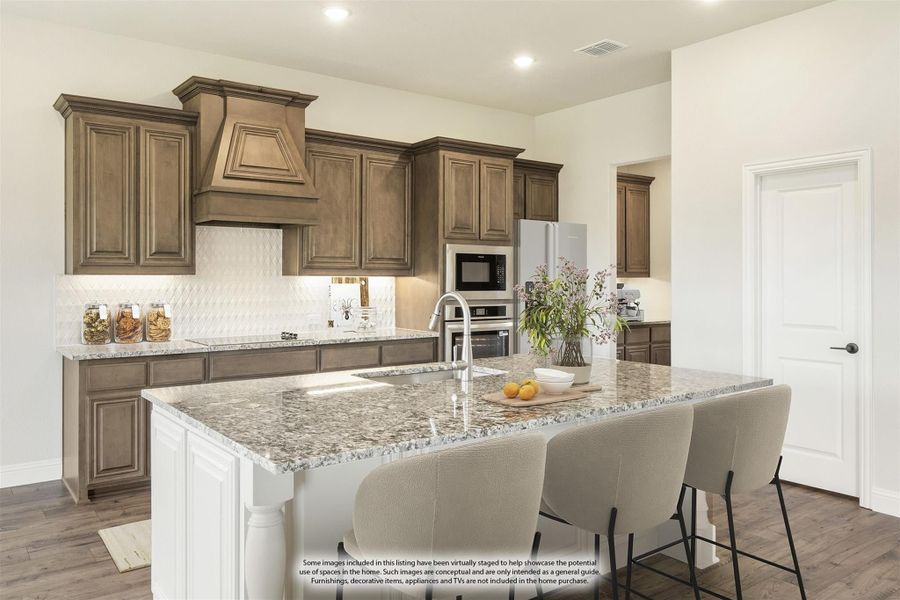 Kitchen with dark wood cabinets, granite island with seating, and stainless steel appliances