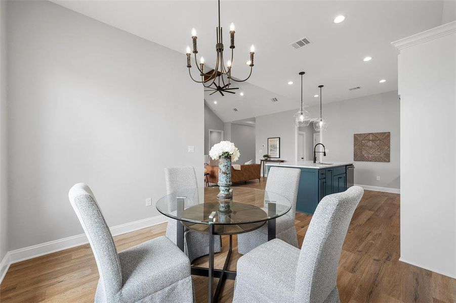 Dining space with light wood-style floors, a chandelier, recessed lighting, and vaulted ceiling Dining space with light wood-style floors, a chandelier, recessed lighting, and vaulted ceiling