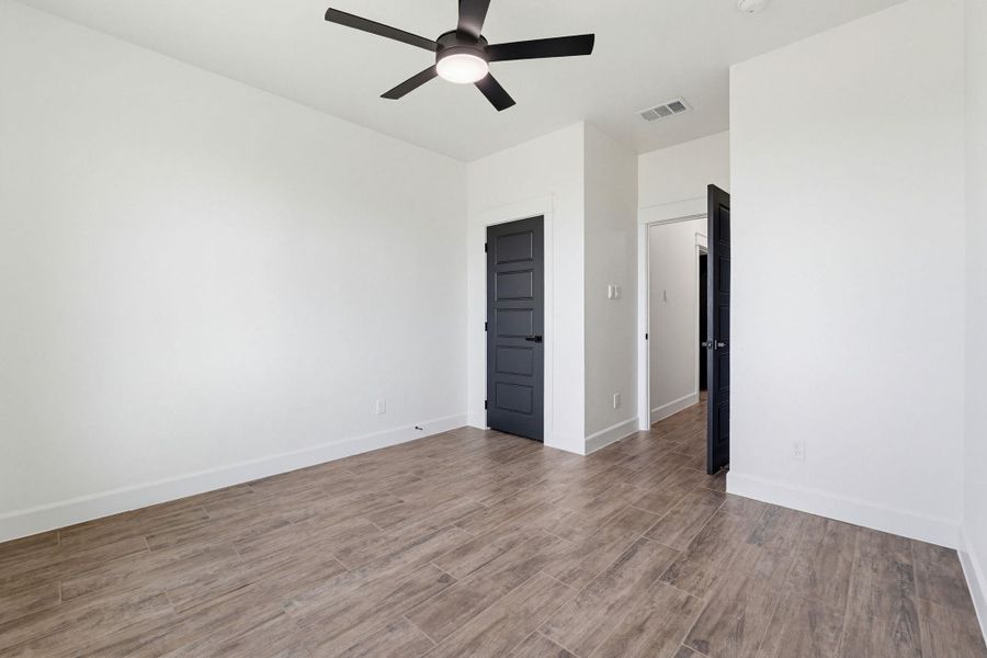A quiet retreat featuring durable wood-look tile flooring and a modern ceiling fan for comfort. A quiet retreat featuring durable wood-look tile flooring and a modern ceiling fan for comfort.
