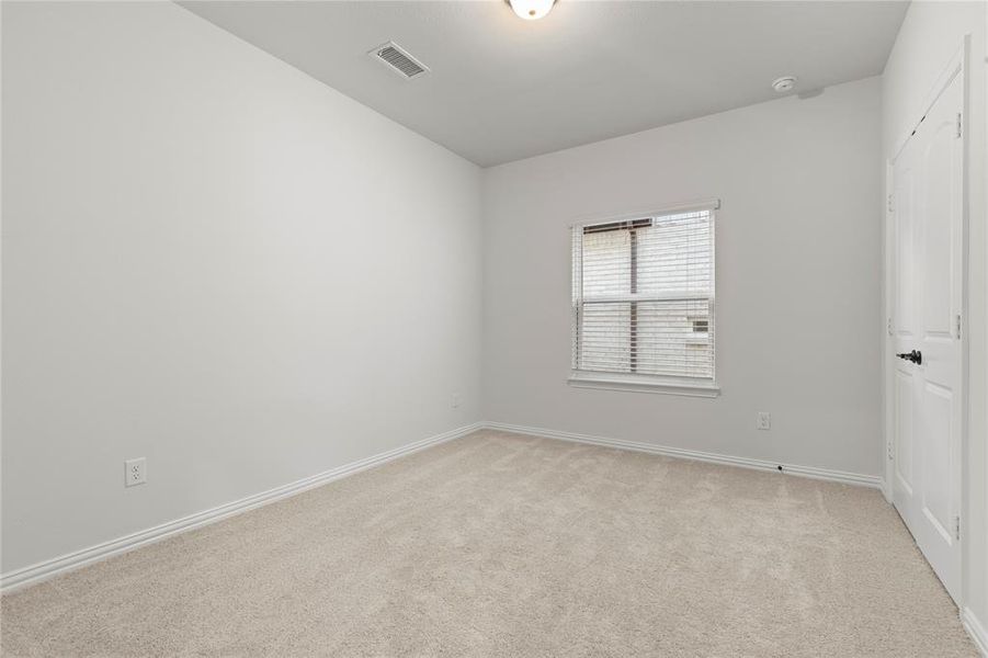 Unfurnished bedroom with light colored carpet