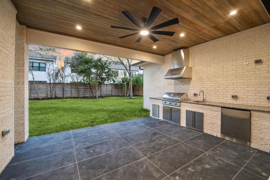 Huge covered back patio with outdoor kitchen, tongue and groove ceiling, and prewired for sound