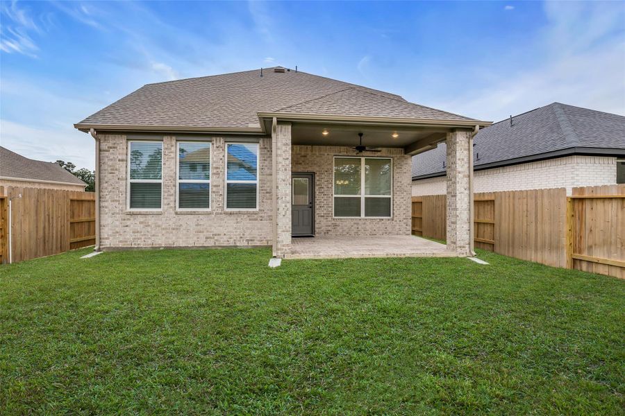 Large Covered Back Patio, with Gas grill stub out, ceiling fan and fenced backyard.
