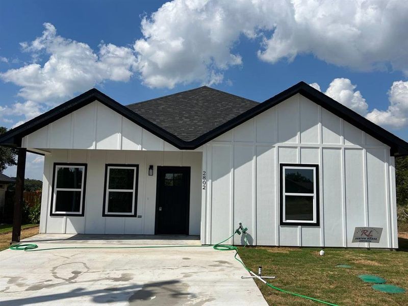 View of front of home featuring a front lawn and a patio area