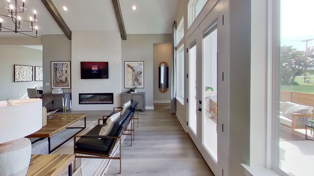 Office area with beamed ceiling, a glass covered fireplace, hanging lights, and light wood finished floors