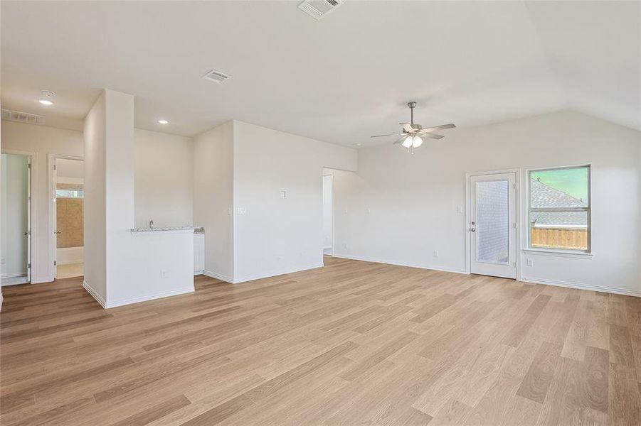 Empty room with lofted ceiling, ceiling fan, and light hardwood / wood-style flooring