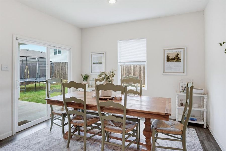 Dining area with wood-finish flooring, recessed lighting, and bright white walls