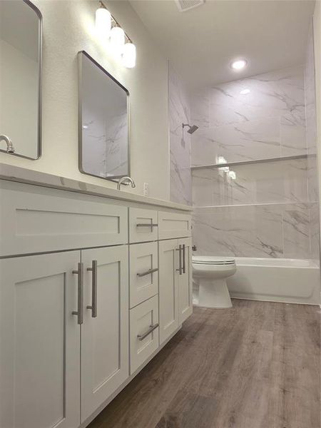 Hallway bathroom with double vanities and sinks.