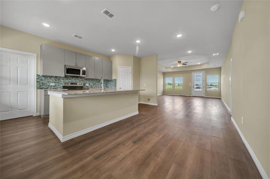 Kitchen featuring gray cabinets, stainless steel appliances, dark hardwood / wood-style flooring, and ceiling fan