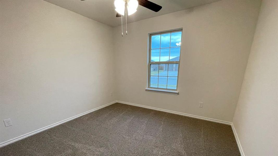 Neutral wall colors, carpeted flooring, and a single window with gridded panes Neutral wall colors, carpeted flooring, and a single window with gridded panes