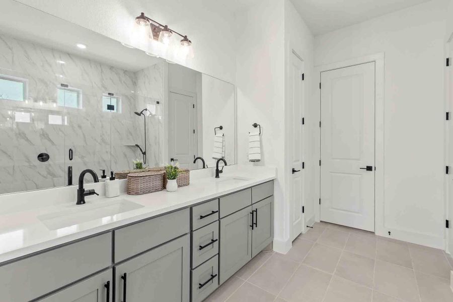 Double vanity with light gray cabinetry and white countertops, featuring matte black fixtures