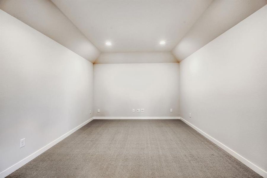 Spare room featuring light colored carpet, vaulted ceiling, and recessed lighting