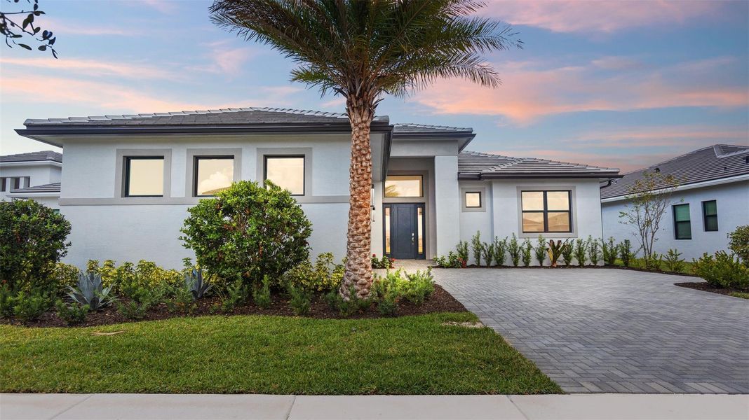 Front exterior of a new home in Cresswind Palm Beach at Westlake, Westlake, FL, highlighting curb appeal (Image 24). Front exterior of a new home in Cresswind Palm Beach at Westlake, Westlake, FL, highlighting curb appeal (Image 24).