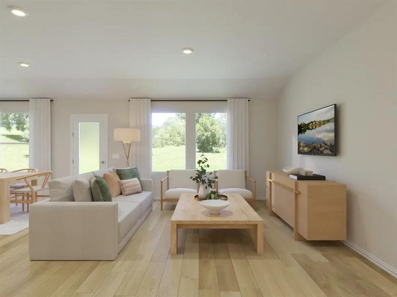 Living area with light wood finished floors and recessed lighting