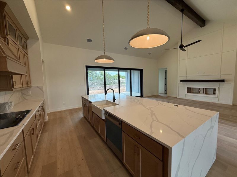 Kitchen featuring visible vents, a sink, light wood-style floors, beamed ceiling, and custom range hood Kitchen featuring visible vents, a sink, light wood-style floors, beamed ceiling, and custom range hood