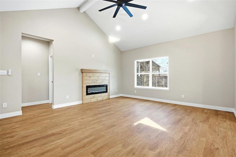 Unfurnished living room with light wood-type flooring, a ceiling fan, a glass covered fireplace, and recessed lighting Unfurnished living room with light wood-type flooring, a ceiling fan, a glass covered fireplace, and recessed lighting