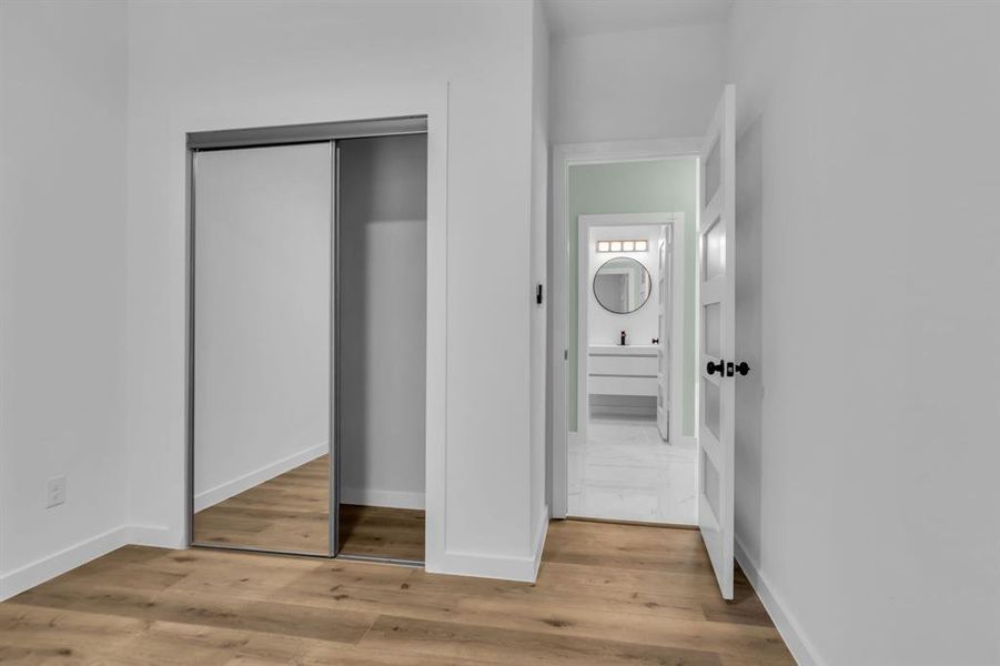 Unfurnished bedroom with a closet and light wood finished floors Unfurnished bedroom with a closet and light wood finished floors