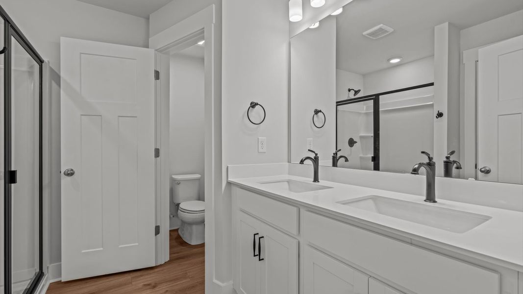 Spacious and modern primary bathroom with walk-in shower and first-class double vanity setup Spacious and modern primary bathroom with walk-in shower and first-class double vanity setup