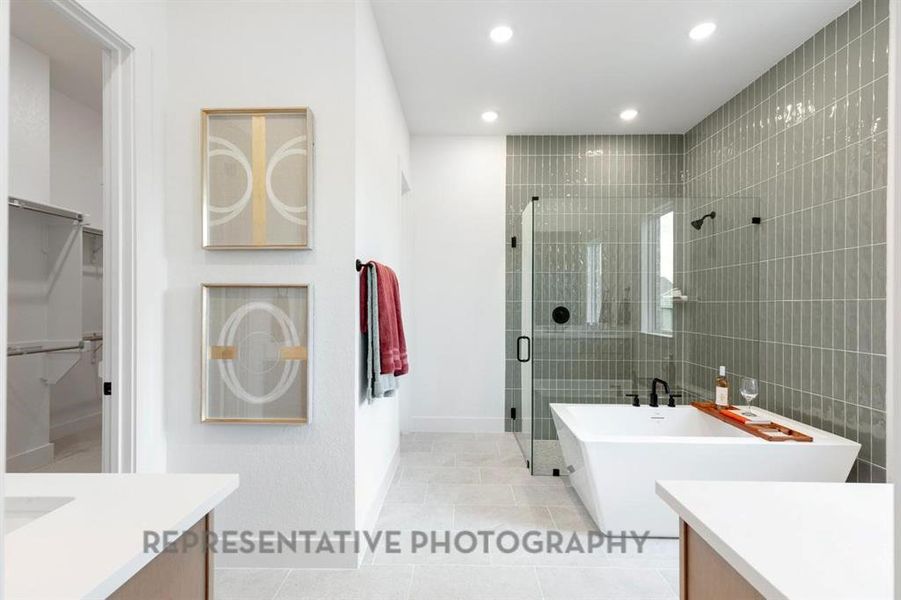Bathroom featuring vanity, a soaking tub, a spacious closet, a stall shower, and light tile patterned floors