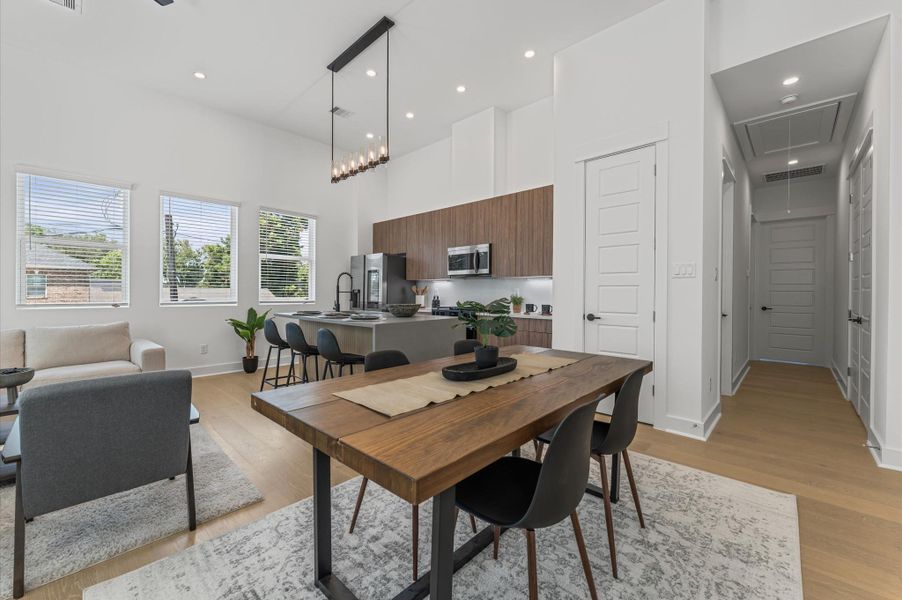 The dining area, part of the open-concept living, dining, and kitchen on the second floor, offers ample space for a large table, making it perfect for family meals or entertaining friends, while seamlessly flowing with the bright, airy atmosphere of the surrounding living space.