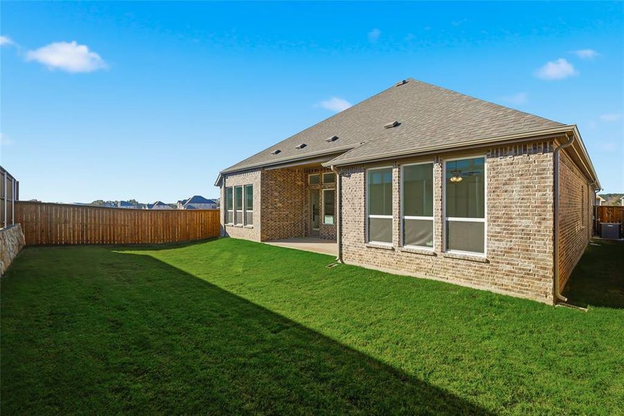 Rear view of house with a patio area, brick siding, a fenced backyard, and roof with shingles Rear view of house with a patio area, brick siding, a fenced backyard, and roof with shingles