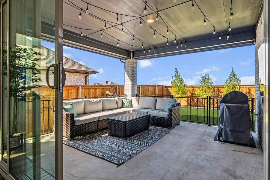 Fenced backyard featuring am oversized patio and grilling area that is fenced in for comfort.