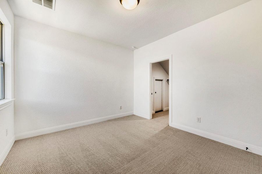 Empty room with light carpet and baseboards Empty room with light carpet and baseboards