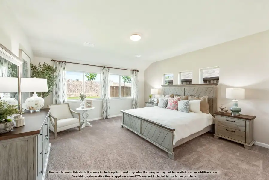 Spacious master bedroom with gray wood bed frame, carpet flooring, and large windows with patterned curtains