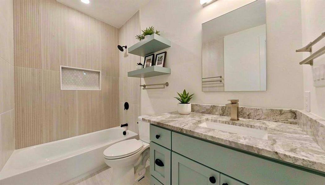 Contemporary bathroom featuring a light blue vanity with a stone countertop and an integrated rectangular sink
