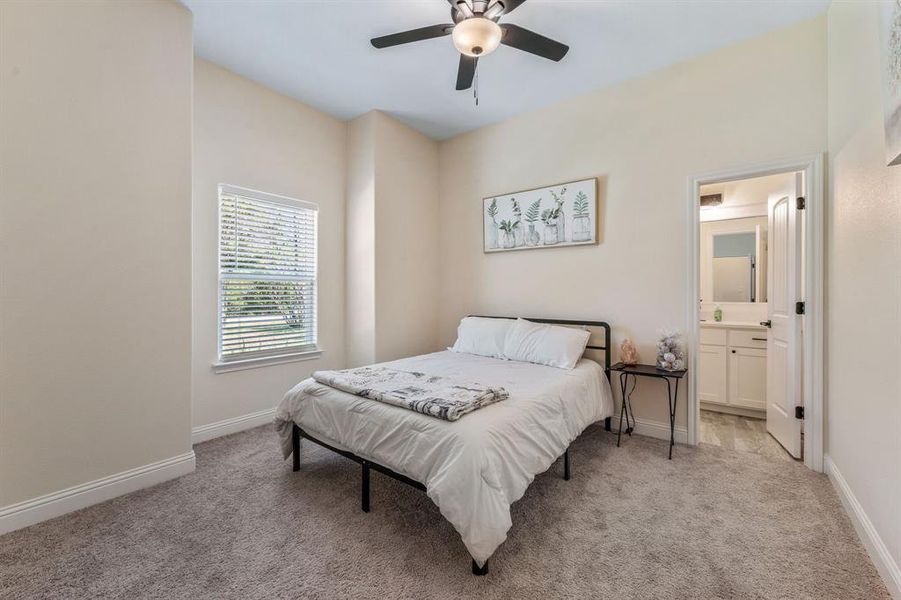 Bedroom with light carpet, ceiling fan, and connected bathroom Bedroom with light carpet, ceiling fan, and connected bathroom