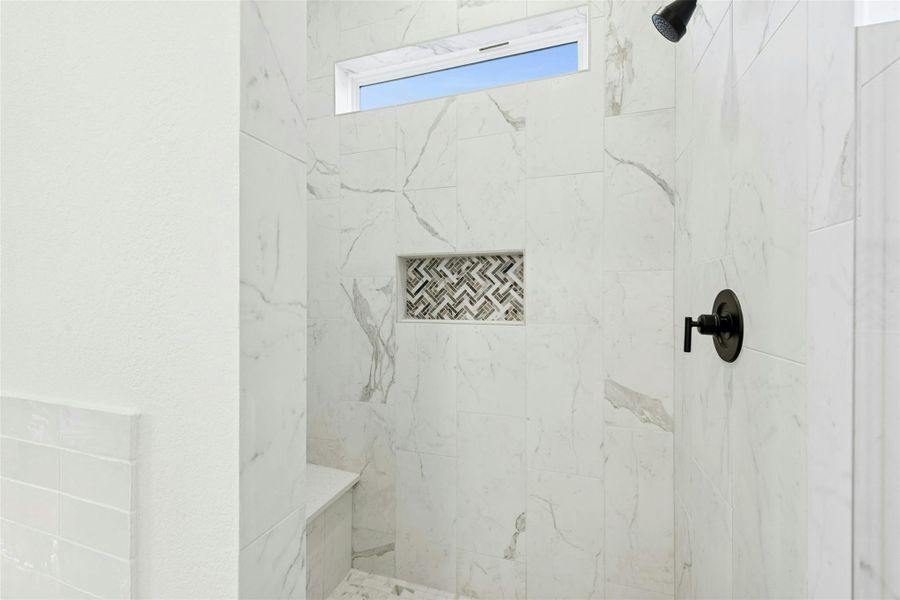 Full bath with a marble finish shower