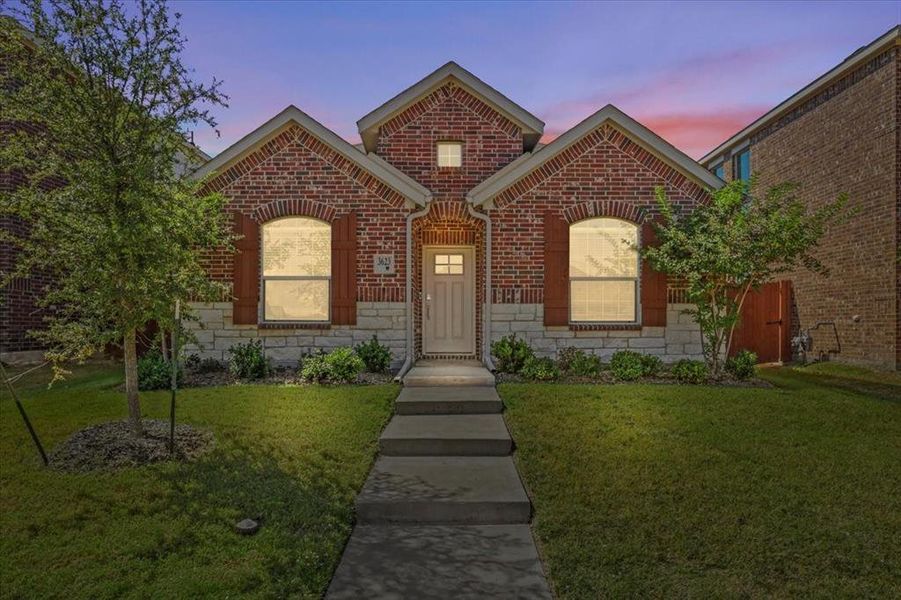 View of front facade with stone siding, a front lawn, and brick siding View of front facade with stone siding, a front lawn, and brick siding